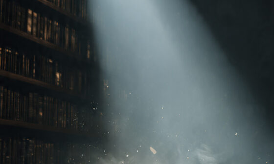 An open book illuminated by light in a dark library, representing the search for truth and understanding beyond ignorance.