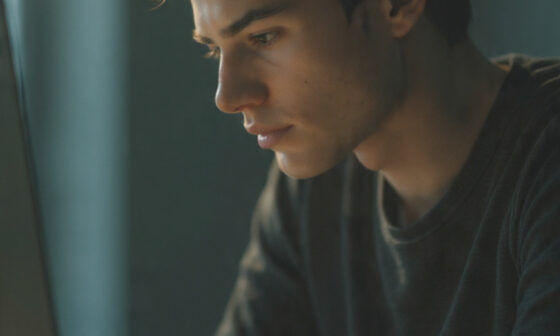 A focused individual working intently at a desk with a blurred background symbolizing distraction-free concentration toward their goals.