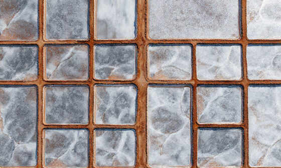 Aerial view of geometric salt evaporation ponds reflecting sunlight, symbolizing systematic effort distribution and maximizing impact.