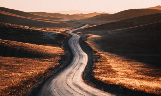 A long road stretching toward the horizon, symbolizing patience, repetition, and the slow compounding process required for lasting success