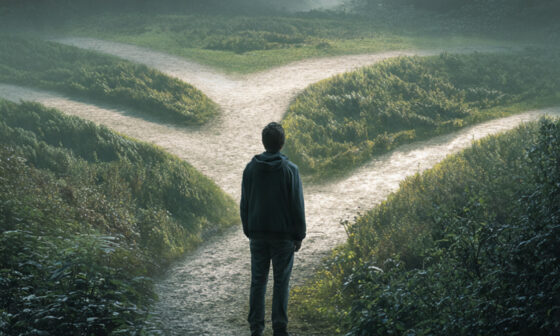 A figure standing at a crossroads with one bright path and several dark, tangled paths, symbolizing that not everything one is allowed to do is beneficial