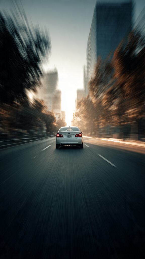 Image of a car driving away from a blurry background: "Symbol of moving forward from past trauma and accidents."