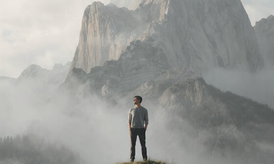 person standing confidently on a small hill representing early knowledge and overconfidence