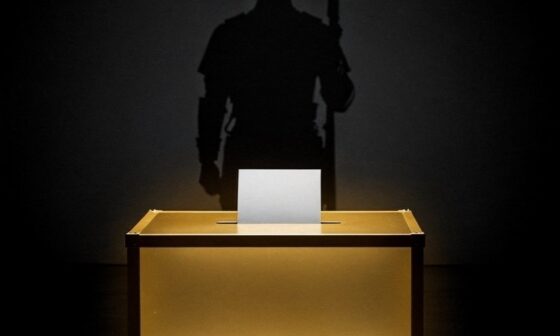 A dramatic, minimalist conceptual graphic showing a single voting ballot box glowing with crisp gold light, casting a long silhouette of a guard standing watch over a dark background.